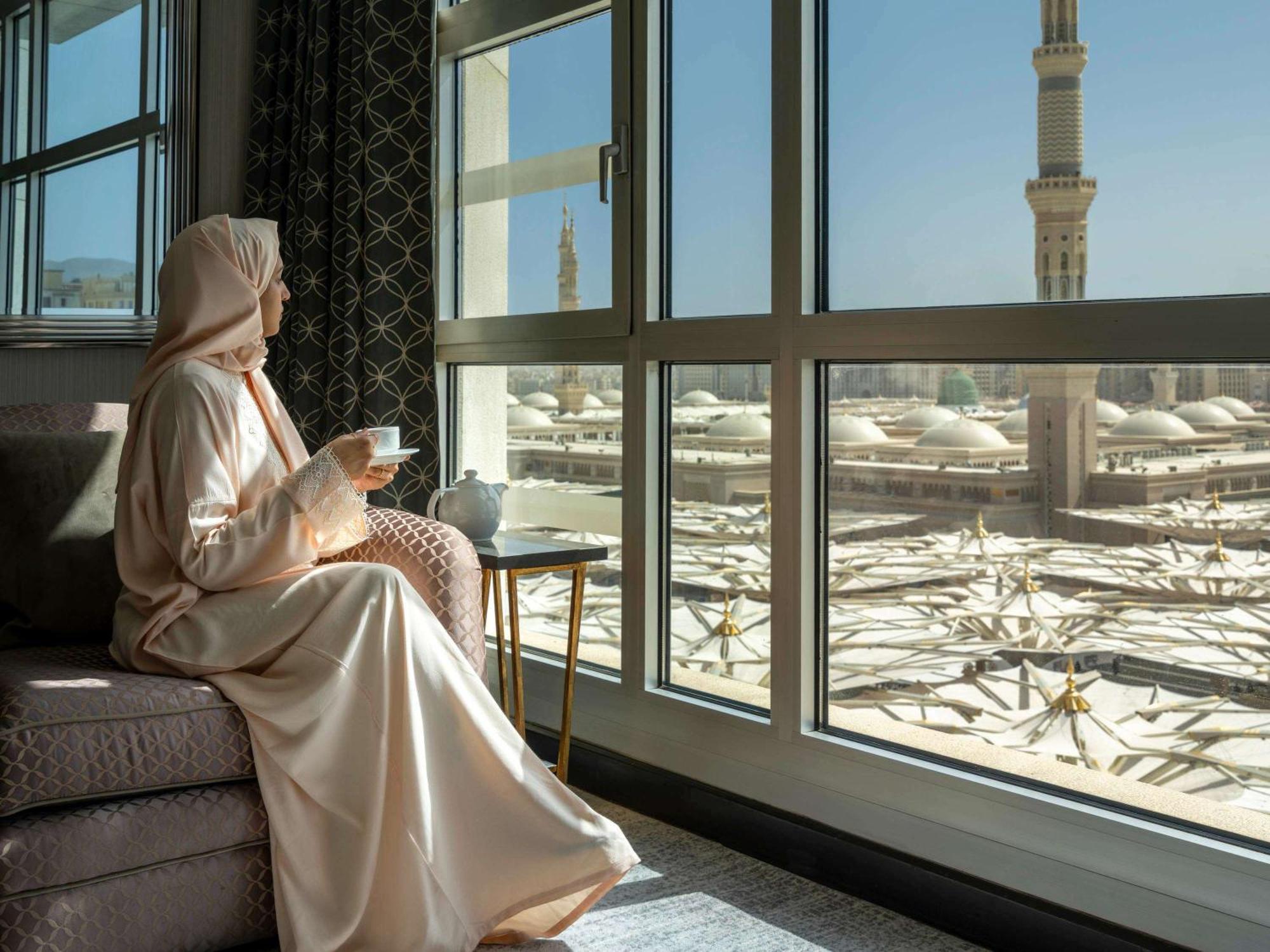 Отель Anwar Al Madinah Moevenpick Медина Экстерьер фото A guest enjoys a view of the Haram from a room at the Kingdom Tower Hotel